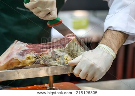 Cutting slices of cured iberian ham .