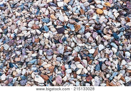 Background of different sizes and colors of wet sea pebbles, stones, beach rocks.