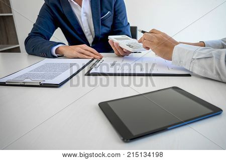 Businessman being analysis and making the decision a car insurance policy Agent man is holding the calculator and waiting for his reply to finish.