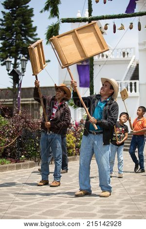 March 24,2016 San Pedro la Laguna, Guatemala: men holding up wooden ratchet during Easter Week procession