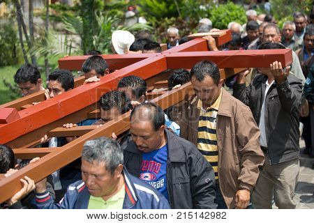 March 25, 2016 San Pedro la Laguna, Guatemala: mayan men carrying a wooden cross during Easter procession