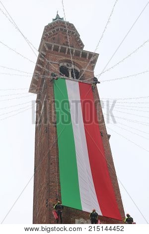 Vicenza, Vi, Italy - December 4, 2015: Firefighters With A Big Italian Flag And The Tower Of Ancient