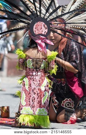 March 6, 2016 San Miguel de Allende, Mexico: indigenous woman and child dressed in traditional costumes performing ritual at the Senior de la Conquista celebration