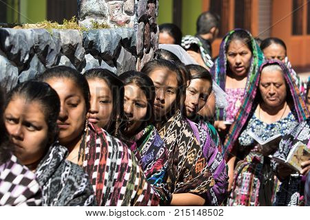 March 25, 2016 San Pedro la Laguna, Guatemala: mayan tzutujil women carrying a heavy float on the street of the small town during Easter holidays