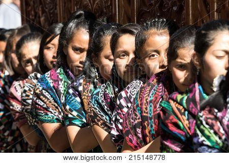 March 25, 2016 San Pedro la Laguna, Guatemala: mayan tzutujil women carrying a heavy float on the street of the small town during Easter holidays