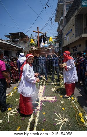 March 25, 2016 San Pedro la Laguna, Guatemala: a float with religious statues is being carried across the colorful ground covering during Easter procession