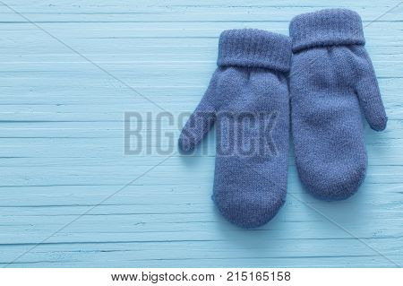 the blue mittens on blue wooden background
