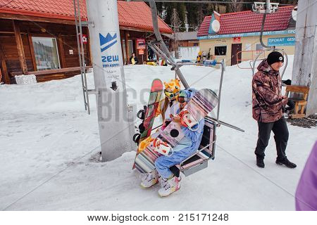 Sheregesh, Kemerovo region, Russia - April 22, 2017: Grelka Fest is a sports and entertainment activity for ski and snowboard riders in carnival costume. Young people in carnival costumes on elevator.