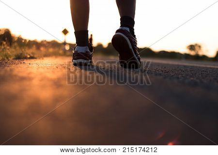 Solhouette of foot running on road in healthy and winner