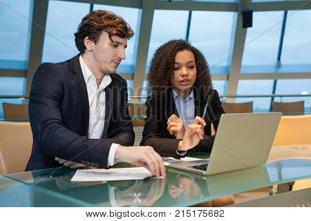 Business people having meeting around table in modern office.