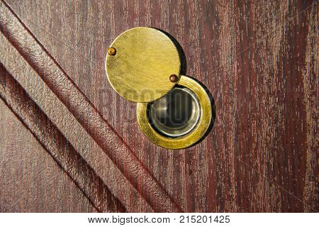 Peephole on wooden door - judas hole spyhole.