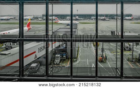 Heathrow Terminal 5 London UK - September 25 2017: Looking out from Terminal 5 at the apron area for British Airways. Early misty morning shot with BA planes parked and taxying.