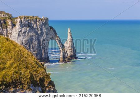 Specific cliffs in Etretat in the Upper-Normandy region in Northern France at low tide: the needle rock and the stone arch.