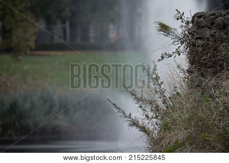 Close up of the water fall in a park with mist rising above the water with a space for text.