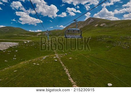 Aerial ropeway high in the mountains of Caucasus with grass plains and cow pastures in the background