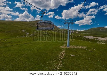 Aerial ropeway high in the mountains of Caucasus with grass plains and cow pastures in the background