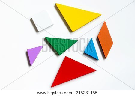 Straggled tangram puzzle wait to complete the shape on white background