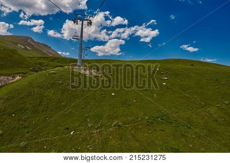 Aerial ropeway high in the mountains of Caucasus with grass plains and cow pastures in the background