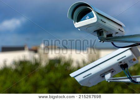 Security Cctv Camera Or Surveillance System With Residential Dwellings On Blurry Background