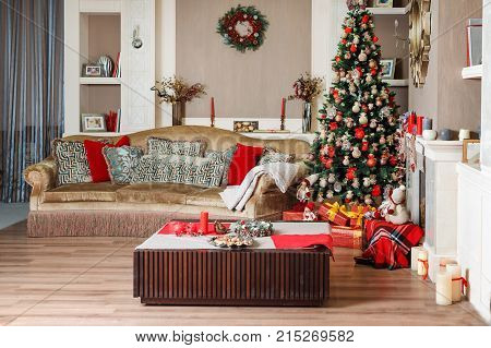 Cozyness And Home Comfort. Sofa Near The Decorated Christmas Tree And Fireplace With Firewood. Winte