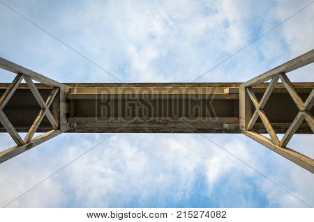 The underside of the Justoy Bridge in Lillesand, Norway. Blue sky and white clouds above