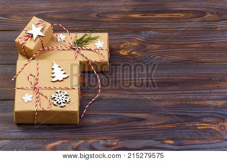 Three Festive Boxes in craf Paper Decorated with Snowflakes and star on Wooden Table. Top View.