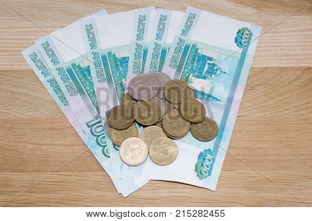 Russian 1000 rubles with coins on wooden background