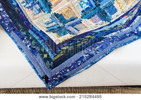 patchwork, culture, design, applique, creativity, sewing concept - there are flowers, leaves, dots, plants and insects on the print of blue colored quilt made in american technique - piecework