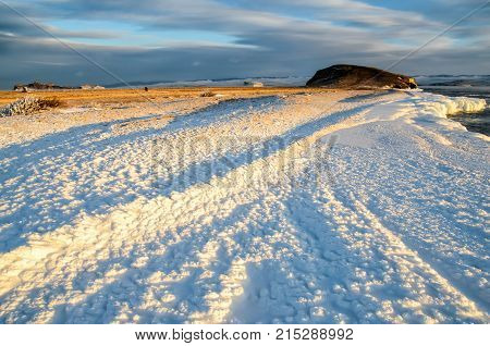 Ice floes floating on the fog water in the lake Baikal and hill, Russia. Sunset