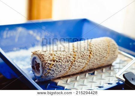 tray with white paint and roller for repair
