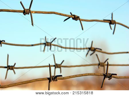 The barbed wires against blue sky on background
