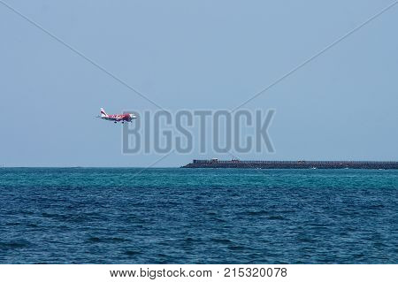 Bali Indonesia - November 25 2012: AirAsia Airbus A320 landing at Ngurah Rai International Airport on runway protruding in sea.