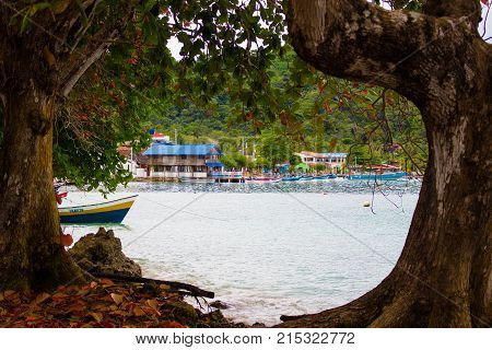 Blue beach of Sapzurro town from a view framed by trees. Colombia, Chocó