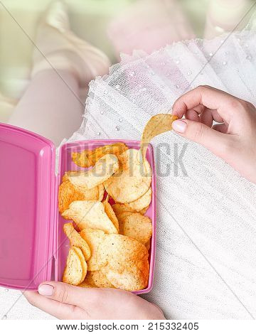 ballerina eating chips from a pink container