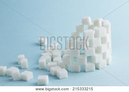 Tower of cubes of sugar and sugar cubes on a blue background