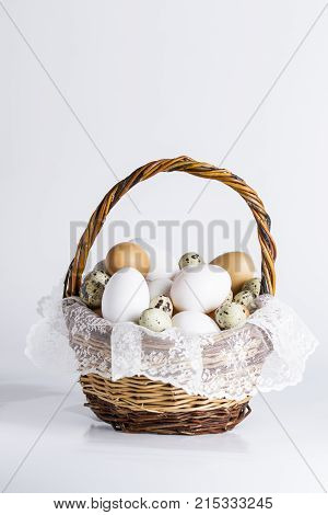 basket with various eggs on a white background
