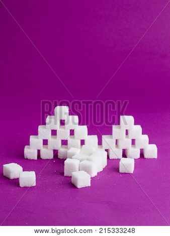 pyramids with cubes of sugar on a pink background