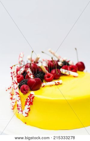 yellow cake and dessert berries and meringues on a white background