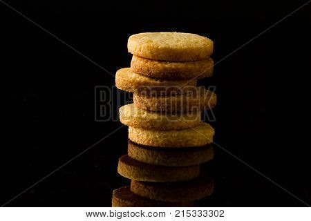 a tower made of shortbread cookies on a black glossy background