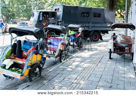Yogyakarta - October 2017: Traditional rikshaw transport on streets of Yogyakarta, Java, Indonesia. Bicycle rikshaw remains popular means of transport in many Indonesian cities.