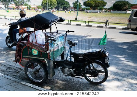 Yogyakarta - October 2017: Traditional rikshaw transport on streets of Yogyakarta, Java, Indonesia. Bicycle rikshaw remains popular means of transport in many Indonesian cities.