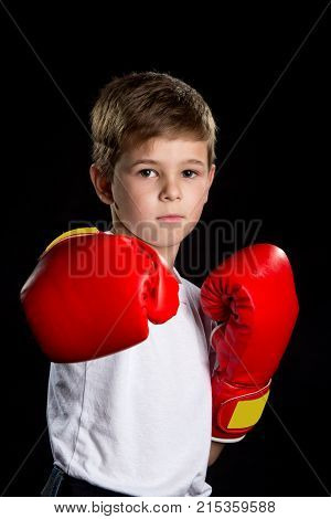 Confident serious boxer portrait. Straight attack kick in red boxing gloves.