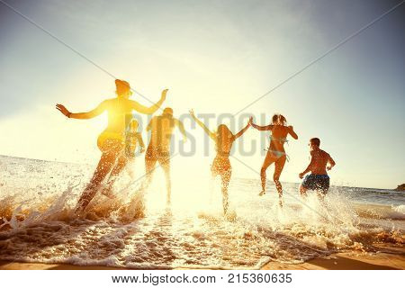 Big group of people having fun at sunset beach