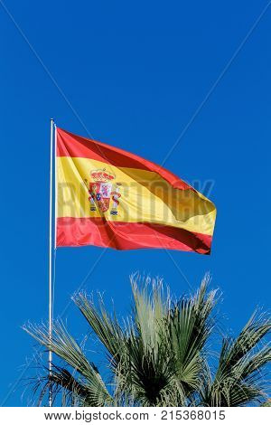 Flag of Spain over a blue sky.
