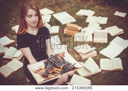 A Girl Holding A Book Burning In Nature In Summer Garden