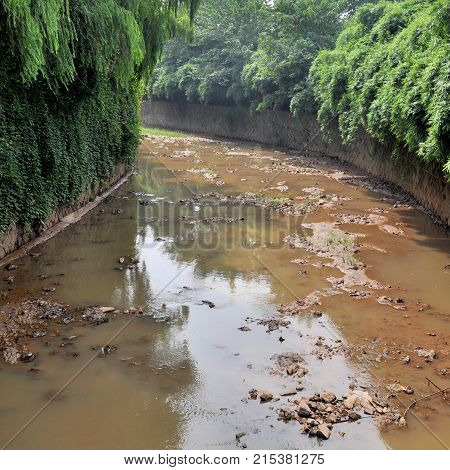 A polluted river in the city. The toxic water flowing out of the sewers.