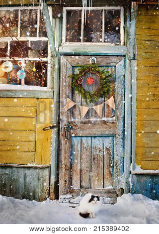 an old wooden door decorated with Christmas wreath and flags, garlands