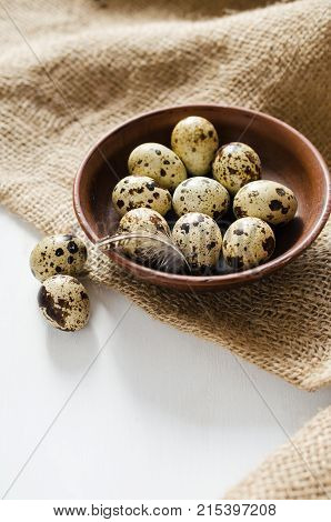 Fresh Organic Quail Eggs in a Ceramic Bowl on Burlap. Rustic stile. Selective Focus.
