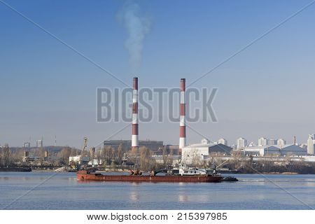 Two striped pipes smoke against a blue sky horizontal