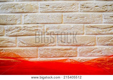 Beige brick wall with a red cloth. Large bricks. The background.